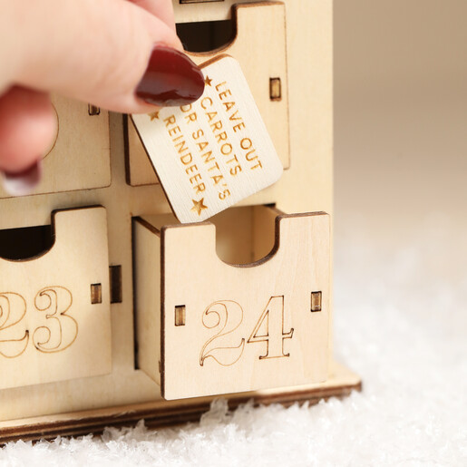 Hand pulling out number twenty four drawer with festive message inside