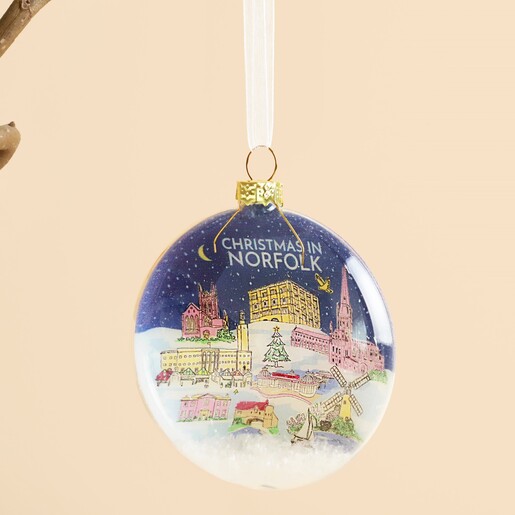 Close up of glass Norfolk bauble showing snowy landscape illustration