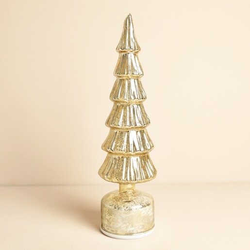 Gold glass ribbed Christmas tree standing light decoration unlit on a neutral background