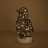 Illuminated wire penguin light with warm glowing fairy lights in the dark