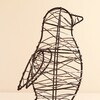 Close-up of black wire penguin light detailing the woven fairy lights