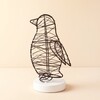Freestanding black wire penguin light on a round white base