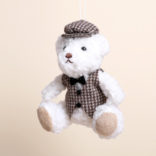 Close up of plush boy bear Christmas decoration wearing houndstooth waistcoat and cap