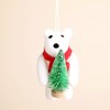 Close up of white felt polar bear decoration wearing red scarf and holding mini tree
