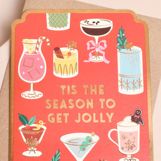 Close-up of festive cocktails and gold lettering on Stormy Knight Christmas card