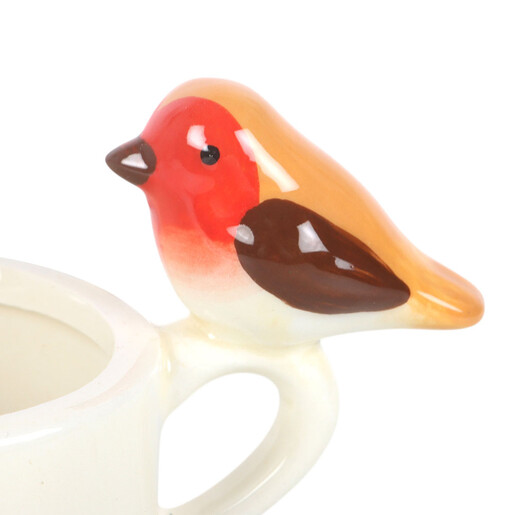 Close-up of the painted ceramic robin detailing perched on the tealight cup handle