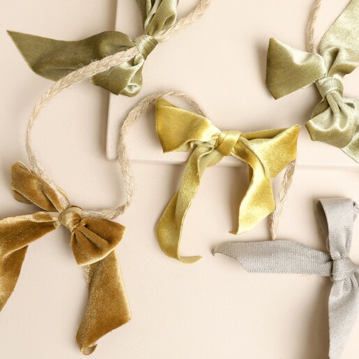 Close-up of multi-coloured plush velvet bows on braided hanging cord