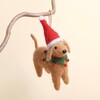 Felt dog hanging Christmas decoration wearing a red Santa hat and green collar