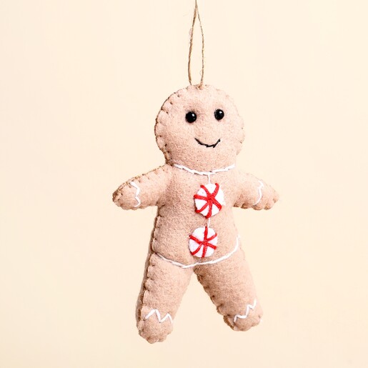 Close-up of felt gingerbread man decoration featuring embroidered face and peppermint swirl buttons