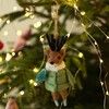 Felt reindeer hanging Christmas decoration wearing green ski jacket and blue ice skates