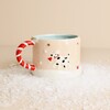 Ceramic winter wishes mug displaying embossed dalmatian holding a santa hat
