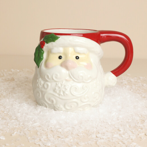 Front view of sculpted ceramic Father Christmas mug with Santa face on faux snow