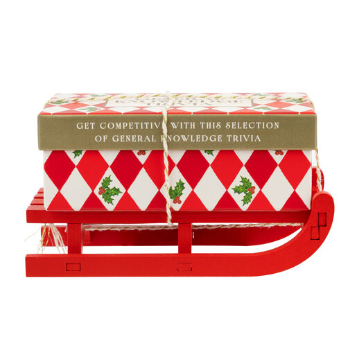 Side view of the festive general knowledge trivia quiz box on a mini red sleigh.