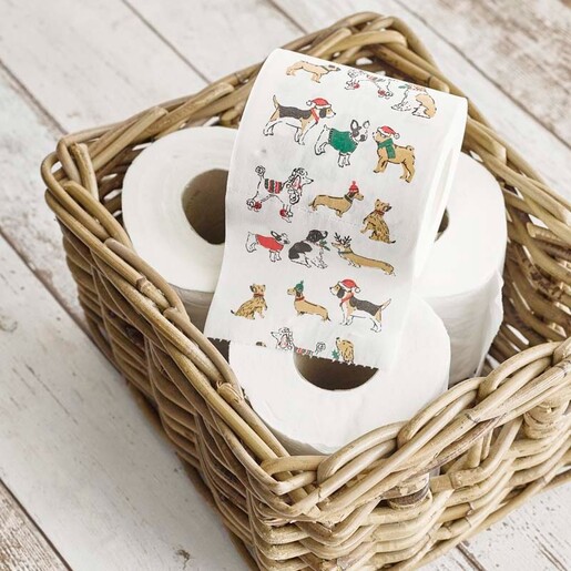 Novelty dog print toilet roll unrolled in a rustic wicker basket with plain rolls