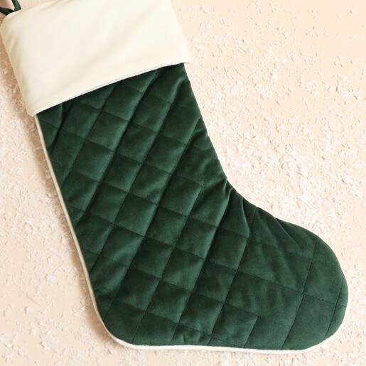 Close-up of dark green quilted velvet Christmas stocking with cream cuff.