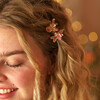two festive hair clips in curly hair 