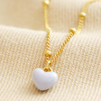 Blue Enamel Heart Pendant Necklace in Gold on Beige Fabric
