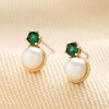 Green Crystal and Pearl Stud Earrings in Gold on Beige Fabric