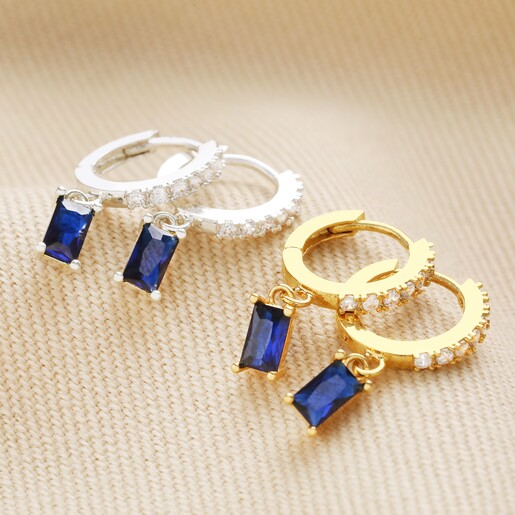 Silver Also Available Blue Stone and Crystal Charm Huggie Hoop Earrings in Gold With Silver Pair Also Available on Beige Surface