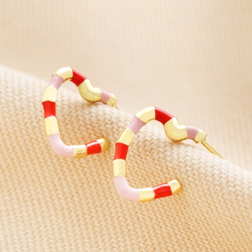 Pink and Red Enamel Striped Heart Hoop Earrings on Beige Fabric