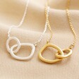 Organic Interlocking Hoops Necklace in Silver next to gold on top of neutral coloured fabric