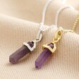 Amethyst Crystal Point Pendant Necklaces in gold and silver on beige fabric