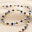 Close Up of Semi-Precious Stone Bead Necklace in Blue on Beige Fabric 