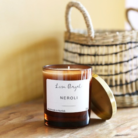 lisa angel neroli candle with gold lid stacked at the side and basket