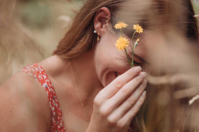 Carly Rowena holding a flower